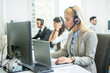 © Bojan - Beautiful young female customer support operator with headset working on laptop in call centre