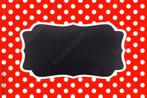 classic red background with symmetrical white polka dots and an empty chalkbo...