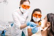 © pantovich - Two dentists in protective glasses treat the client's teeth in a modern clinic