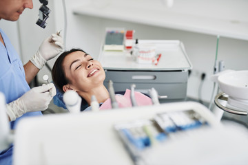 Wall Mural - Beautiful young lady smiling during checkup at dental clinic