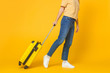 © Damir Khabirov - Travel and tourism concept. Young woman wearing casual clothes walking with suitcase isolated on yellow background