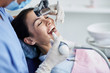 © Yakobchuk Olena - Young woman with closed eyes having dental procedure at clinic