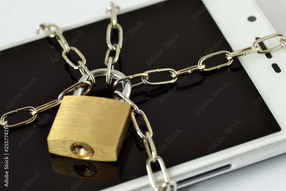 Close-up of smartphone locked with chain and padlock - Concept of mobile security and data privacy