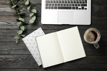 Flat lay composition with laptop and notebook on wooden table, space for text. Blogger's workplace