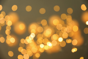 Blurred view of gold lights on dark background. Bokeh effect