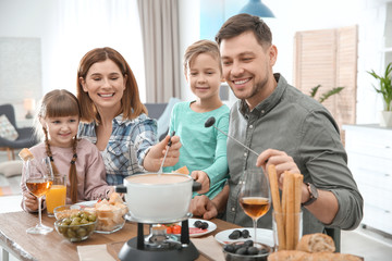 Canvas Print - Happy family enjoying fondue dinner at home