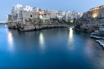 Polignano a Mare, Puglia - Italy. Sunset at Cala Paura gulf with Bastione di Santo Stefano and Lama Monachile beach on background