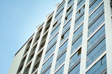 Multistory new modern apartment building. Stylish living block of flats. Modern, new executive apartments and with deep blue summer sky