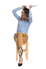 Canvas Print - young businesswoman holds a blue clipboard above his head