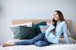 © BestForYou - Happy woman talking on smartphone at home on the couch.