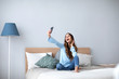 © BestForYou - Beautiful happy girl making self on the bed at home.