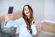 © BestForYou - Beautiful woman at home do selfie on cell phone.