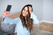 © BestForYou - Beautiful young smiling woman with a phone in her hands takes a selfie.