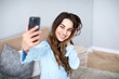 © BestForYou - Beautiful young smiling woman with a phone in her hands takes a selfie.