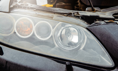 Poster - Car headlight with an open car hood. The concept of changing the bulb in the car, no lighting. Problems with the car. Fluid replacement in the car.