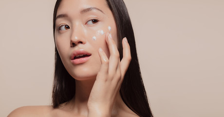 Poster - Applying moisturizer to her face