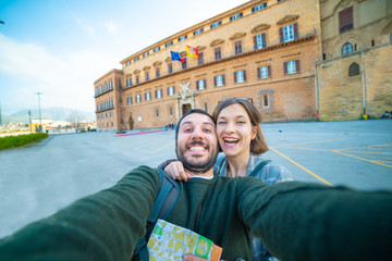 Wall Mural - happy tourist couple traveling in Palermo, Sicily and taking selfie outside the Palazzo dei Normanni (Palace of the Normans) or Royal Palace, the oldest royal residence in Europe. 