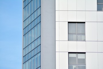 New office building in business center. Wall made of steel and glass with blue sky. 