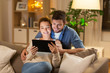 © Syda Productions - technology, internet and people concept - happy couple using tablet computer at home in evening