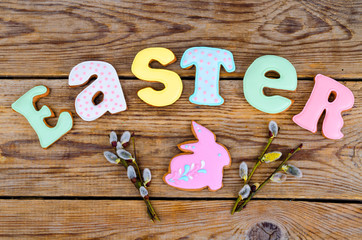 Homemade cookies in form letters EASTER and eggs on old wooden backgroun.