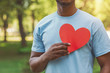 Black man holding red heart on his chest
