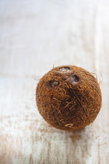 Wall Mural - whole coconut on a white wooden background.