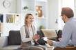 © Seventyfour - Young blonde smiling woman sitting on couch and looking at counselor during discussion of ways of solving problem