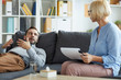 © Seventyfour - Young patient of counselor lying on couch, looking at mature professional and explaining his problem
