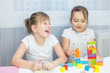 © Andreshkova Nastya - Children play with an educational toy on table in the children's room. Two kids playing with colorful blocks. Kindergarten educational games