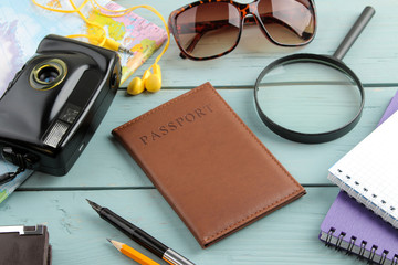 Travel concept camera, passport, map and shells on a blue wooden table. relaxation. holidays.