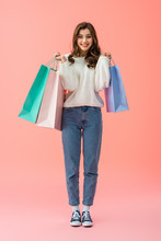 Full Length View Of Smiling And Attractive Woman Holding Shopping Bags On Pink Background