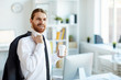 © Seventyfour - Happy young successful office worker in white shirt holding his jacket on shoulder while looking at you