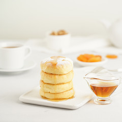 Wall Mural - Fried cheese cakes, sweet cheese pancakes on white plate on white background. Home tea party