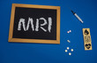 © taiga - wooden tablet on blue medical table with the word MRI