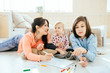© Iryna - Cute preteen boy and toddler girl having fun on warm floor, brother, sister and their mother drawing with colored pencils, family leisure together in living room, underfloor heating.