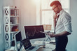 © gstockstudio - Modern trader. Thoughtful young businessman in formalwear analyzing data using digital tablet while working in the office