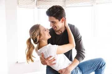 Sticker - Portrait of excited couple laughing and dancing while having fun at home