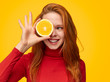 © kegfire - Pretty ginger girl covering eye with orange slice