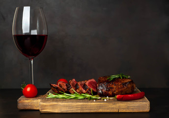 Beef steak on a cutting board, grilled steak with red wine, greens and spices.