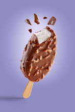 Chocolate Covered Ice Cream With Nuts On A Purple Background  Bitten On Top With Chocolate Bits. Taste Explosion