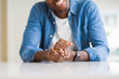 © Krakenimages.com - Close up of crossed hands of african man over table smiling
