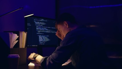 Very Tired frustrated business executive working late at night in the office, he is staring at the computer screen and receiving an error message