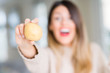 © Krakenimages.com - Young beautiful woman holding fresh potato at home very happy and excited, winner expression celebrating victory screaming with big smile and raised hands