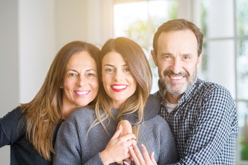 Beautiful family together. Mother, father and daughter smiling and hugging with love at home.