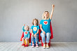© Sunny studio - Family of superheroes playing at home