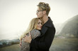 © Natalie Faye - Stylish blond couple hugs on beach