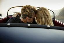 Young Couple Touch Forehead While They Sit In Convertible