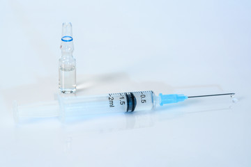 syringe on a light blue background with medicinal solution. 2 ml syringe close up, with an ampoule o