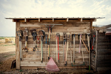 Farm Tools Hanging On A Wood Shed