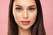 Close up Brown hair model face portrait. Elegant attractive woman with pergect skin and natural make up against pink bacground. Beauty salin and cosmetics concept.